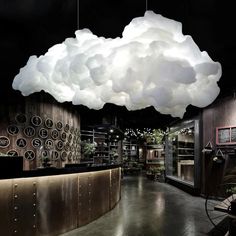 a large cloud hanging over a room filled with furniture and lighting fixtures on the ceiling