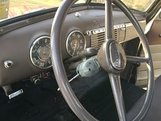 the steering wheel and dashboard of an old car