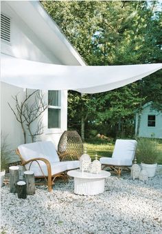 an outdoor living area with furniture and trees in the background