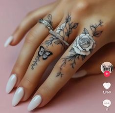 a woman's hand with tattoos on it and two roses tattooed on the fingers