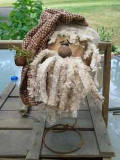 a stuffed animal with a hat and beard on top of a wooden pallet in the yard