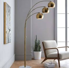 a living room with a chair, lamp and potted plant on the floor in front of it