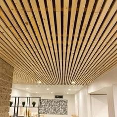 a living room filled with lots of furniture and wood slats on the ceiling above