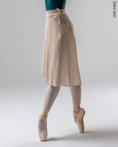 a woman in ballet clothes is posing for the camera