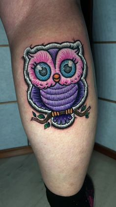 an owl with blue eyes and pink feathers is on the leg, while it's surrounded by leaves