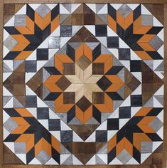 an orange and black geometric design on wood