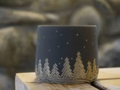 a wooden table topped with a black and white cup on top of it's side