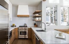 a modern kitchen with stainless steel appliances and wood cabinets