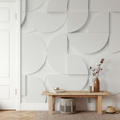 a room with a wooden table and white wall paper on the walls, along with a vase filled with flowers