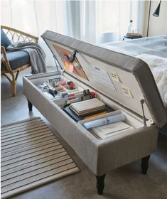 an open suitcase sitting on top of a bed next to a rug and table with items in it