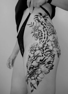 a woman with a tattoo on her back holding onto the side of her body,