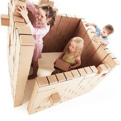 three children playing in a cardboard castle