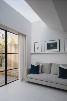 a living room filled with furniture and pictures on the wall next to sliding glass doors