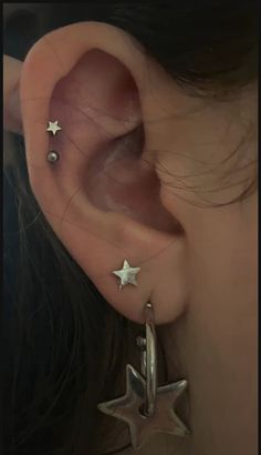 a woman's ear with three stars attached to it