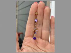 This dangly gold belly button ring features beautiful purple crystals in a long, chandelier shape. Gorgeous option for summer! Drop jaws with this body jewelry. Available with several metal & CZ colors (choose at checkout!) **PACKAGE INSURANCE: Please either upgrade to priority express shipping at checkout if you would like to insure your package OR you can also purchase insurance separately Insurance up to $100 for $1.50 here: https://www.etsy.com/listing/1296961518 Insurance up to $200 for $2.00 here: https://www.etsy.com/listing/1310991679 Details & Size: ♥ 316L Surgical Steel ♥ 14G, 10mm bar ♥ Externally Threaded ♥ Every purchase comes with an Elara gift box For sanitary purposes, piercing items are non-returnable, so please double check sizing and message me if you have any questions! Elegant Gold Belly Rings, Elegant Yellow Gold Body Jewelry For Gift, Elegant Yellow Gold Body Jewelry For Wedding, Elegant Gold Belly Rings Gift, Elegant 14k Gold Belly Rings For Gift, Elegant 14k Yellow Gold Belly Rings, Gold Hypoallergenic Belly Rings, Dainty Gold Belly Rings For Wedding, Elegant Internally Threaded Belly Rings As Gift