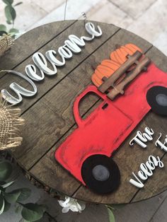 a wooden sign with a red truck and pumpkins on it