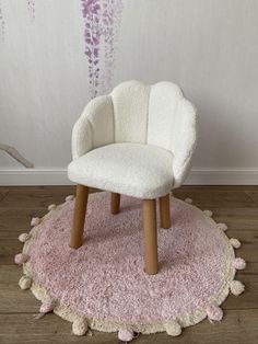 a white chair sitting on top of a pink rug