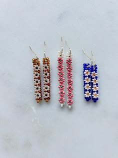 Each handmade pair is unique. Measures: 1: .25" W x 1.5" L 2: .25" W x 2" L 3: .25" W x 1.5" L Materials: Glass miyuki seed beads - 18k gold plated French hooks Seed Bead Charm Patterns, Party Tiny Beaded Earrings, Festival Tiny Beads Drop Earrings, Traditional Tiny Beaded Drop Earrings, Festival Earrings With Tiny Beads, Seed Bead Earrings Ideas, Unique Multicolor Earrings With Tiny Beads, Beaded Ideas, Beadwork Jewelry