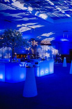 a room with blue lighting and decorated tables