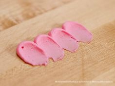 four pieces of pink cake sitting on top of a wooden table