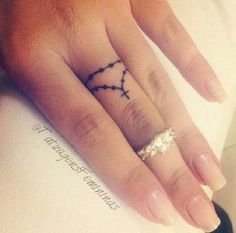 a woman's hand with a small tattoo on it