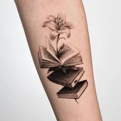 a black and white photo of a book with a flower on it's arm