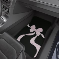 the interior of a car with a pink bow on it's front door mat