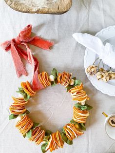 the table is set with plates, napkins and other items to make a wreath