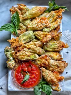 an appetizer platter with grilled artichokes and tomato sauce