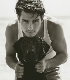 a man holding a dog on the beach