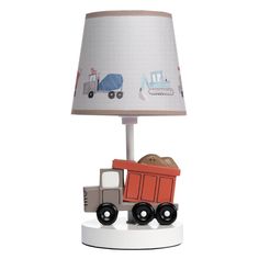 a lamp with a dump truck on it and a light shade over the base that is attached