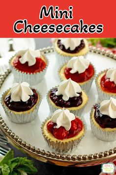 mini cheesecakes are topped with whipped cream and cherries on a silver platter