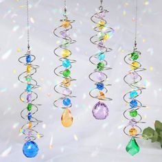 three wind chimes with different colored glass beads hanging from it's sides, on a white background