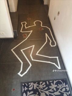 a bathroom floor with a drawing of a man on it