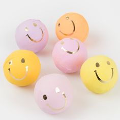 four balls with different colored faces painted on them