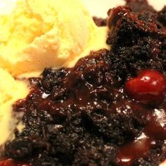 a plate with ice cream, chocolate cake and cherries