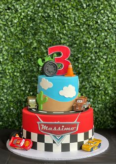 a three tiered cake with cars and trucks on it