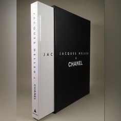 a book with black and white covers sitting on top of a table in front of a gray background