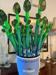 there are many green plastic toothbrushes in the cup