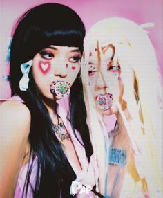 two young women with long black hair and pink makeup