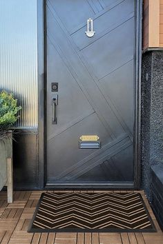 a door is open on the side of a building with potted plants in front