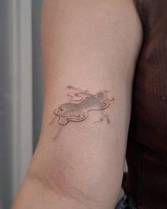 a woman's arm with a small tattoo on the left side of her arm