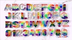 the letters and numbers are made out of colorful plastic beads on a white background with marble slabs