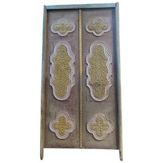 an old metal door with ornate designs on it