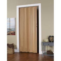 a wooden door in the corner of a room with hardwood flooring and white trim