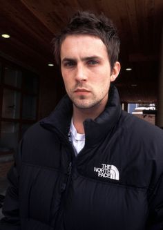 a man wearing a black jacket and white shirt