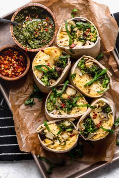 several burritos filled with different types of toppings on top of a tray