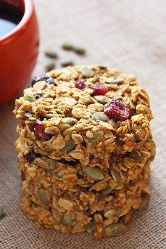 granola cookies with cranberries and pumpkins next to a cup of coffee