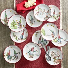 a table topped with lots of white plates covered in cartoon characters and christmas tree decorations