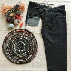 a pair of black jeans sitting on top of a white table next to a rug